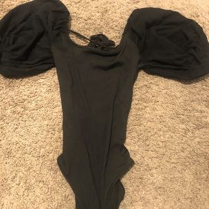 A black body suit with a lace back